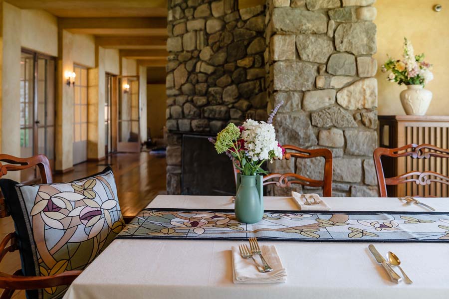 Flowers & Vines Crystal table runner on a styled dining table with matching pillows and soft pastel décor.  Shown at Frank Lloyd Wrights Graycliff Estate.