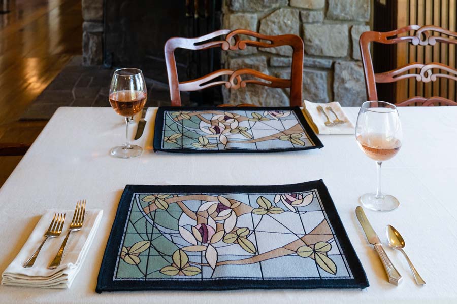 Flowers & Vines Crystal placemat at Graycliff Estate on dining table set with glassware, pastel art-glass inspired design