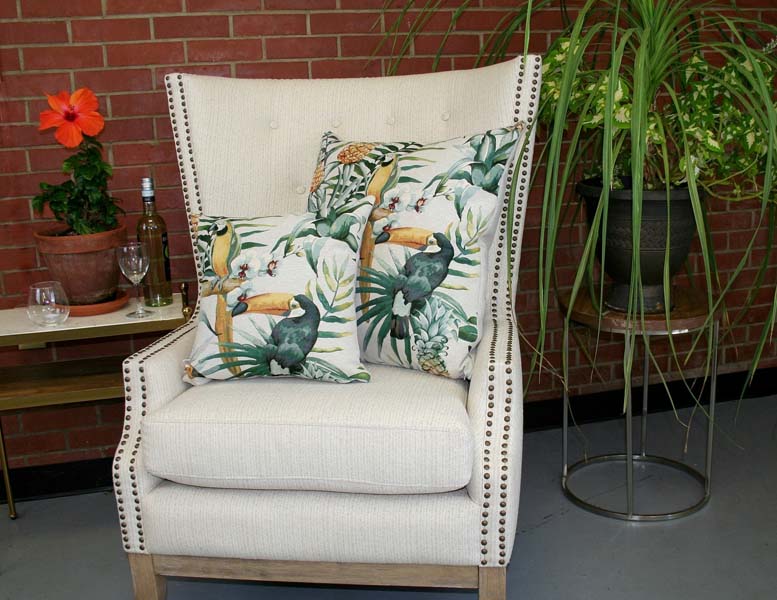 Rennie & Rose Tropical Birds & Foliage Pillows on a chair